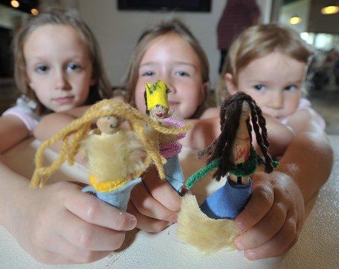 Holly Kelly and Lilly and Ellie Green show off the peg-dolls of postal workers they made at an activity day in Bradford. 