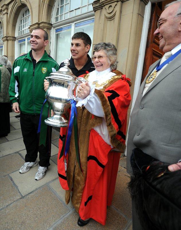 The Lady Mayoress of Keighley proudly holds the trophy with Cougars skipper James Feather and coach Barry Eaton.