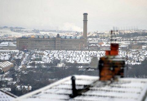 A view across a snowy Bradford towards Lister's Mill.