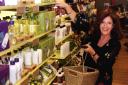 Body Shop founder Anita Roddick stacking shelves in her store in High Street Kensington