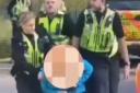 A screenshot from the video showing a woman being arrested after a man was found dead in Bradford