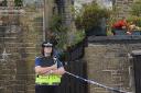 A police officer stands guard at the house in Ivy Bank Lane, Haworth, where two bodies were found