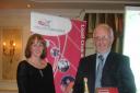 Lucy Birkenshaw from England Athletics presents the prize as best club partnership to regional chair of Bradford Athletics Network, Mike Moss