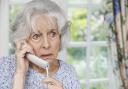 Worried Senior Woman Answering Telephone At Home.