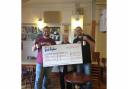 Manorlands ambassador Jackie McGill receives a cheque from Stephen and Robert Naylor, of Naylor's Brewery