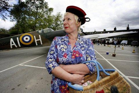 Organiser Pam Howorth stands beside a Spitfire.
