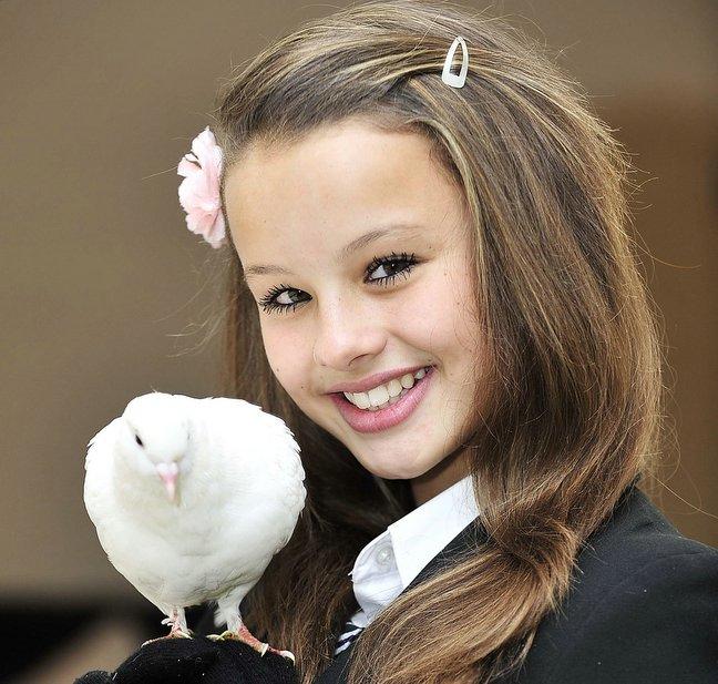 Schoolgirl Rebekah Horsfield has a new “feathered” friend under her wing. 
The white dove flew on to her school bag as she strolled home from class earlier this week, and he has been by her side, on her shoulder and head ever since.