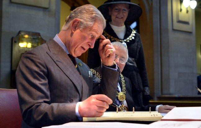 Prince Charles signs the visitors book at City Hall.