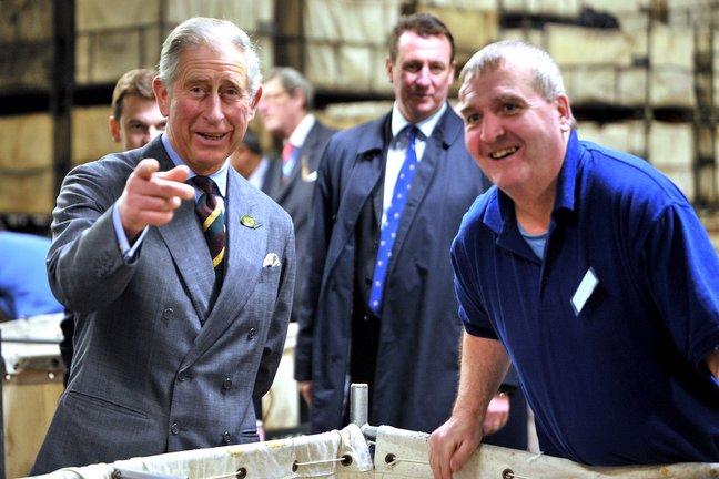 Prince Charles shares a joke about photographers with James McDonald on the production line at Bulmer and Lumb.