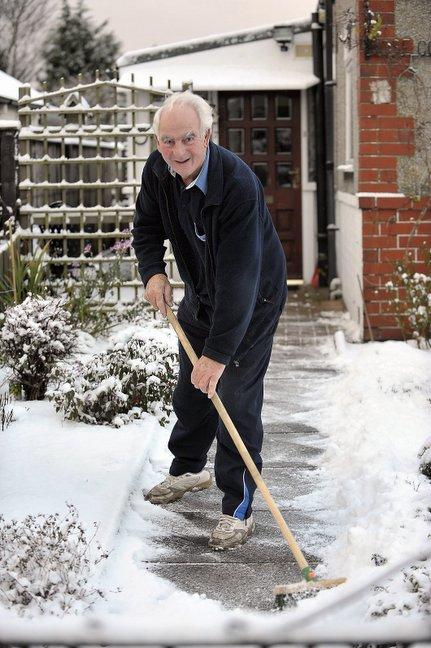 Doug Hobson clears snow from his garden path in Eldwick.