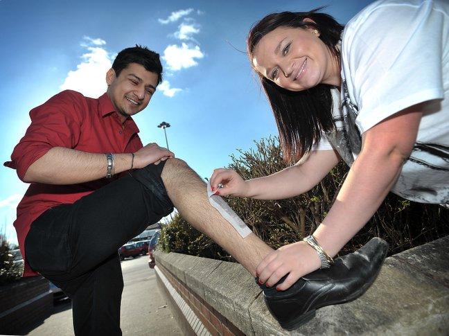 At Specsavers Opticians in Idle's 5 Lanes End shopping centre Jagdeep Kainth has his leg waxed by Vicky Fisher.