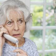 Worried Senior Woman Answering Telephone At Home.