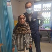 Khanim Bi, aged 103, with Dr Tamjeed Abdul Hakeem, after she had her Covid-19 vaccination at The Bradford Moor Practice at Barkerend Health Centre