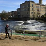 Chris walking beside the weir in Saltaire