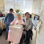 Eight-year-old Khidr (left) and six-year-old Hazim-Idrees (right) deliver food to a Manningham woman