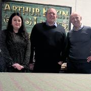 Elkin owner Bill Gorton, centre, and Rochelle Waterman and Francis Dodson of Marton Mills, have a look at Cheviot Lovat Tweed laid out on the cutting table.