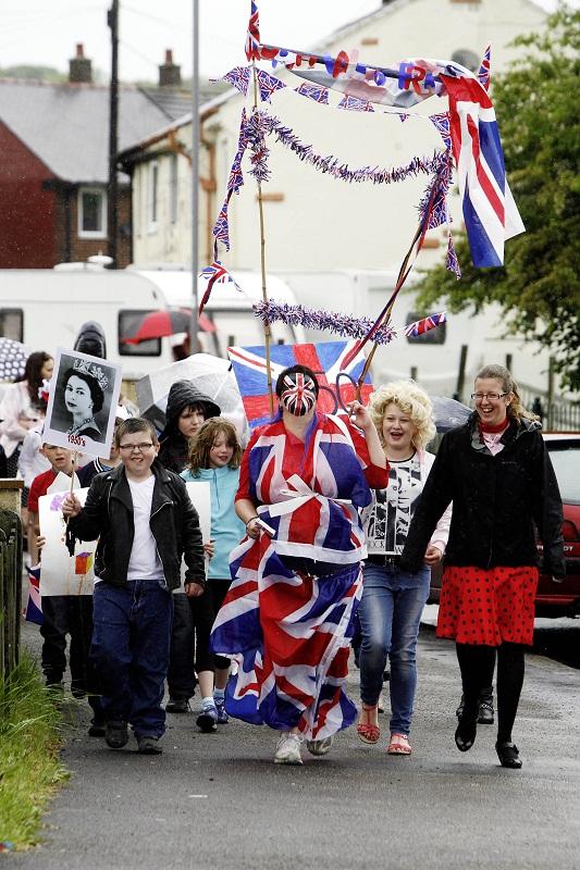Worth Valley Primary School high-level teaching assistant Lil Curr, centre, leads the Queen's Jubilee procession round the Bracken Bank estate in Keighley