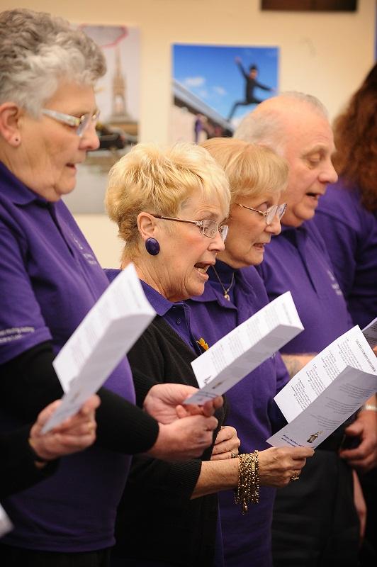 Happy Memories singers perform in the atrium of Bradford University