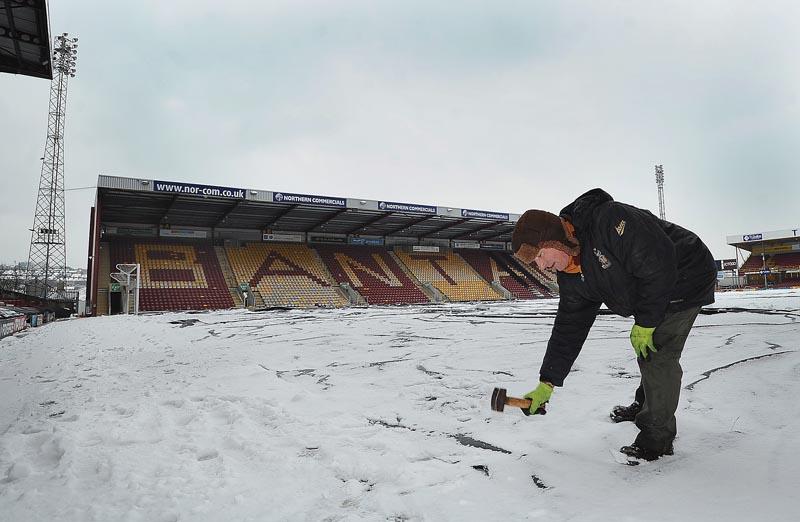 Bradford City's Groundsman, Mick Doyle, secures the covers on the pitch at Valley Parade ahead of more bad weather that saw the match against Bristol Rovers postponed at the weekend