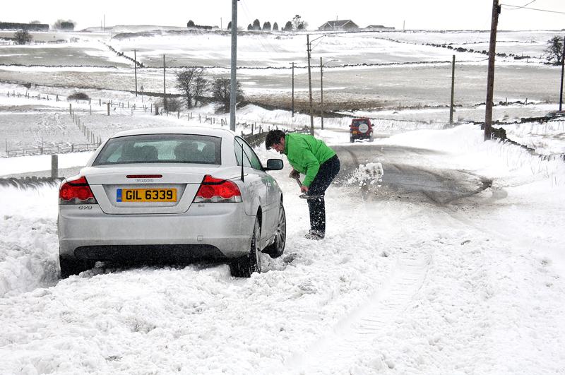 A motorist digs out his car trapped in snow at Allerton  