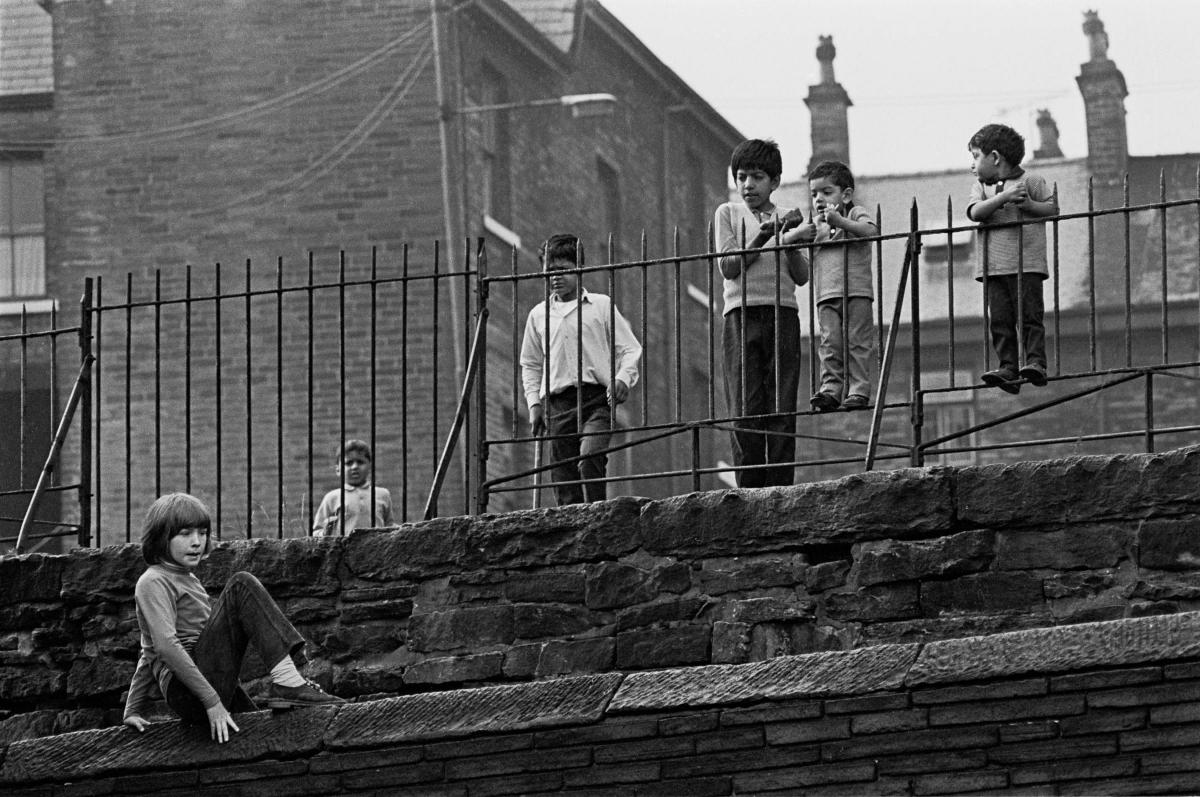 Young children play on walls on their estate in Bradford