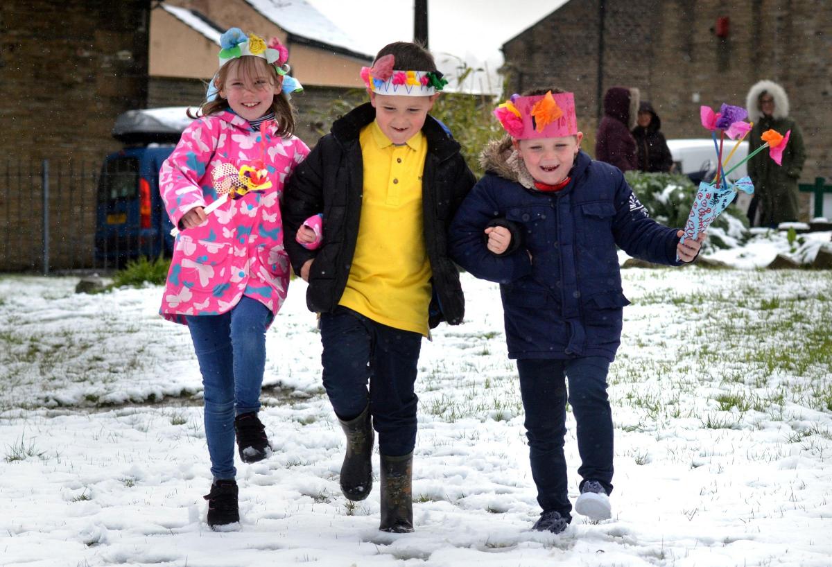 Pupils at Clayton Village Primary School during May Day celebrations, despite the snow. From left, Sophie Ingham, Thomas Lee and Adam Fearnley