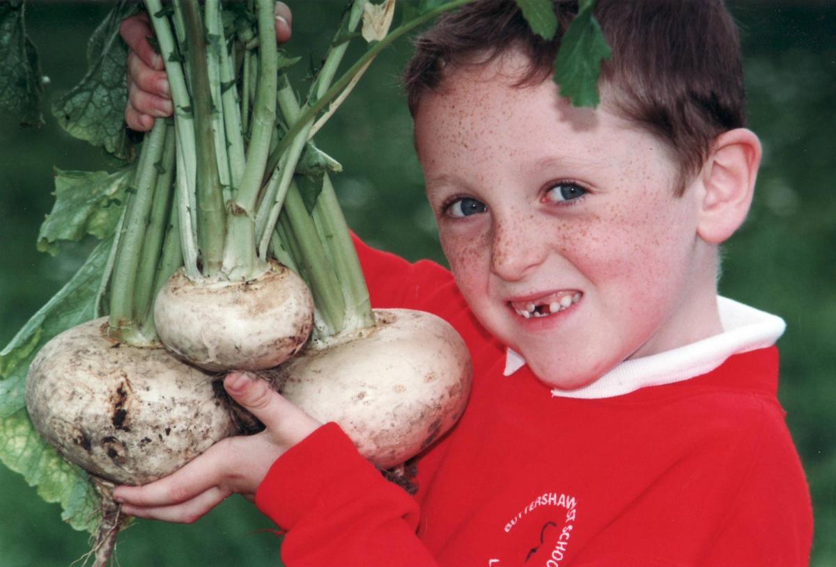 A pupil shows of turnips he's grown in 1997