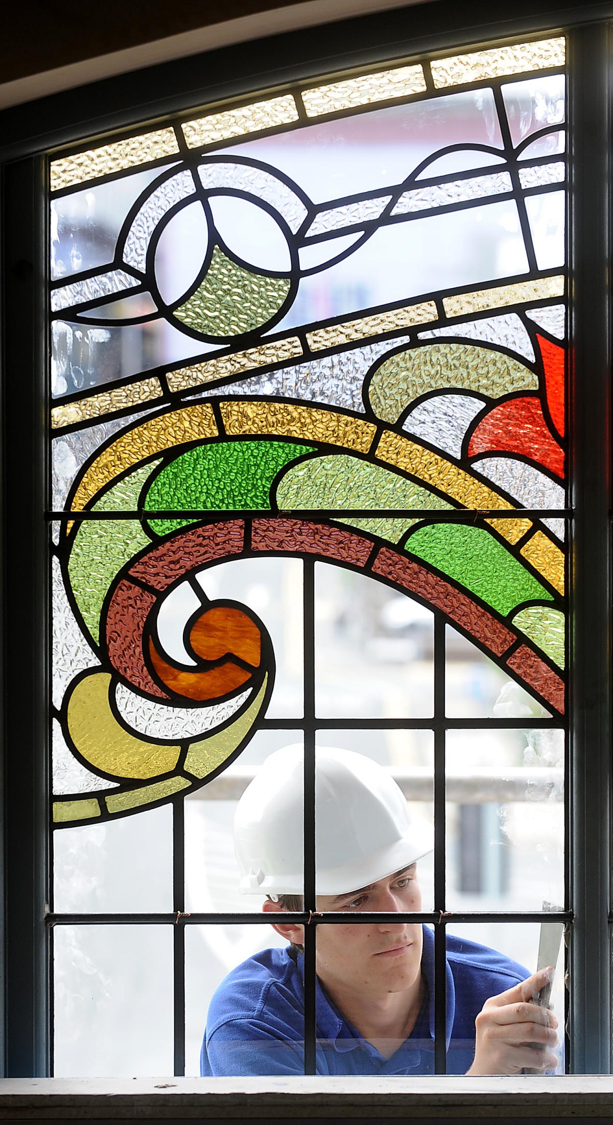 Adam Hague works on one of the stained glass windows at Eastbrook Hall