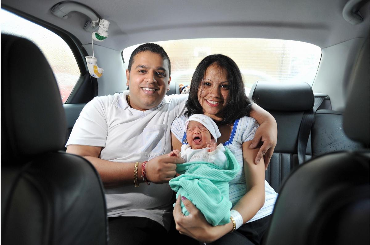 Bhupendra and Sulventi with their new daughter in the back of their Alfa Romeo