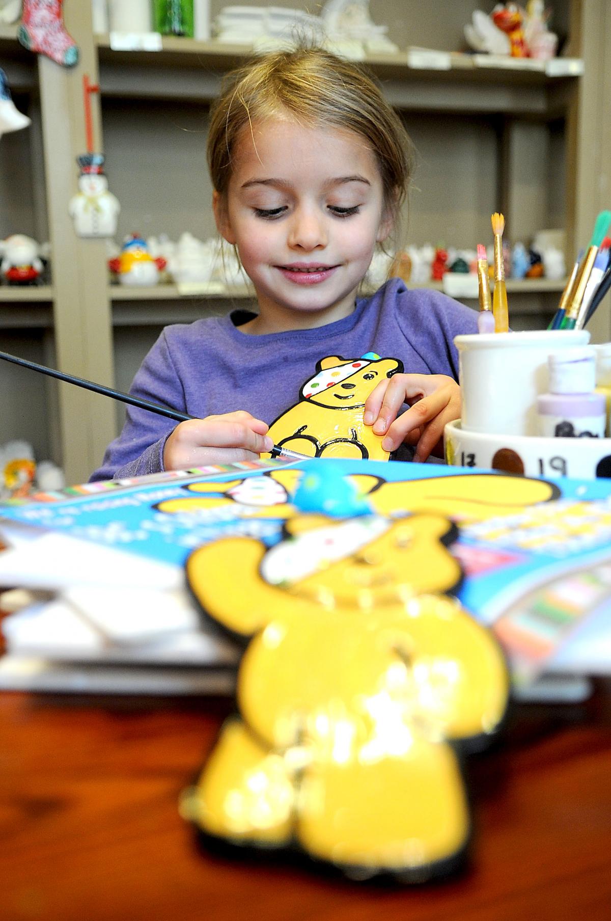 Lucy Allen, 6, painting her ceramic Pudsey Bear