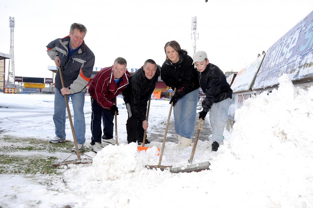 The scene at Valley Parade as the club and spectators fought in vain to save Monday night's game with Darlington. Steve Walker, Charles Murgatroyd, Mick Barker, Rebecca Conley, 17, and Jack Duffy, 13, help clear City’s pitch.