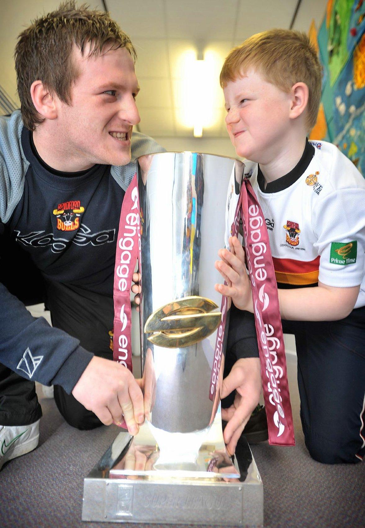 Pupils at Wibsey Primary showed Bulls captain Paul Deacon and fellow player Matt Brooks just how it’s done by hoisting high the Super League trophy. Pupil Jamie Ingham squares up to Bulls star Matt Brooks.