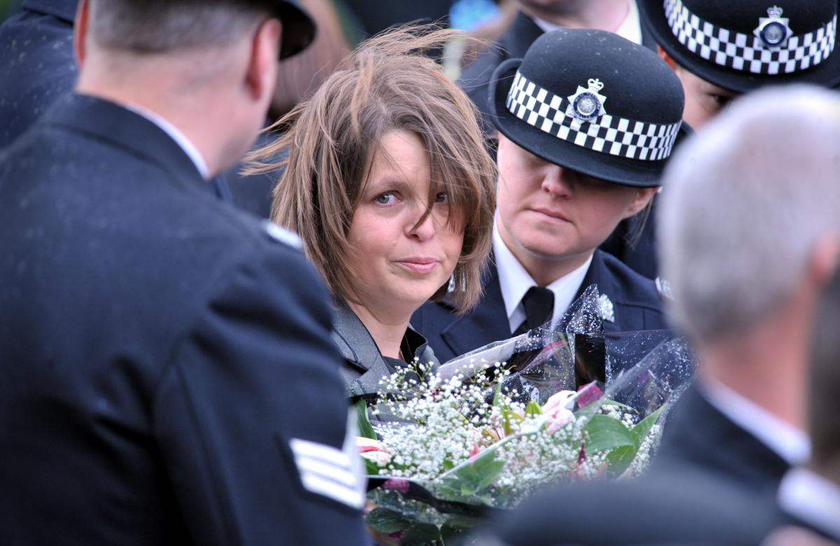 PC Beshenivsky's colleague PC Teresa Milburn, who was shot in the same incident, is comforted by colleagues.