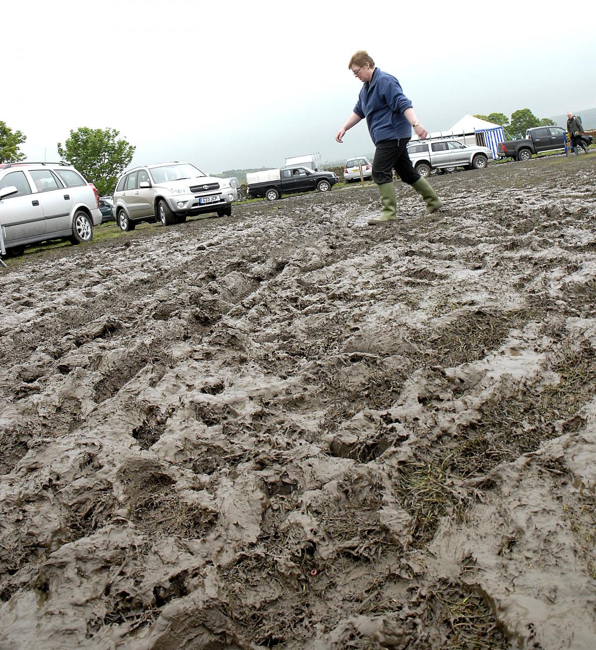 A visitors squelches through the mud at Otley Show.