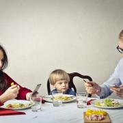 Meals with family and friends should be sociable - yet many people sit at the table with their phones. Pics: PA