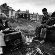 Children sitting on old car seats reading comics - one of the street scenes in Life Goes On. Images: Ian Beesley