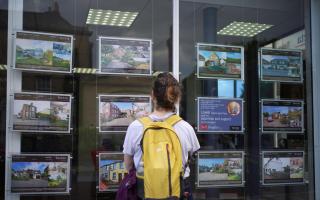 File photo dated 20/07/23 of a woman looking at advertisements in an estate agents window, as asking prices for homes in Britain tumbled in the biggest August fall since 2018 this month as soaring mortgage costs put buyers under pressure, according to a