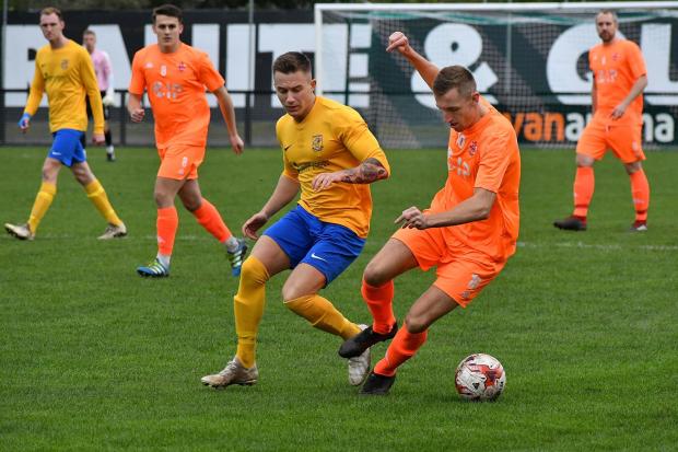Oliver Fearon (orange, on the ball) scored the equaliser against Brighouse Town that has essentially secured promotion for Liversedge. Picture: Richard Leach.