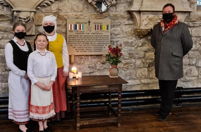 Simon Paul Grybas pictured with Ruta Kisio and her children Smilte and Viktoria by the plaque in Bradford Cathedral