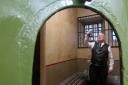 Volunteer Les Vasey in an old cell at Bradford Police Museum