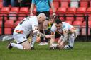 John Davies (left) lends a helping hand to Jordan Lilley at Dewsbury in windy, difficult kicking conditions.