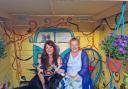 Artist Joanne Scott and Daisy Williams sit inside the hippy-themed garden shelter