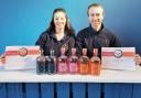 Sarah and Chris Dinnewell, of Dinnewell's Gin Company, with the awards they won at the 2022 International Wines and Spirits Competition