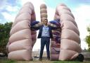 Dr Chris George, NHS medical doctor, beside a large inflatable lung at St Thomas' Hospital in central London, during the launch of the Let's Talk Lung Cancer Roadshow, a national tour of the world's first walk-through lung exhibit. Picture: PA