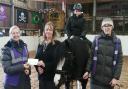 Carla Weatherall and son Ryan present a cheque to Haworth Riding for the Disabled Association. Image: Funeral Partners