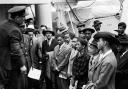 PA photo dated 22/06/48 of Jamaican immigrants welcomed by RAF officials from the Colonial Office after the ex-troopship HMT 'Empire Windrush' landed them at Tilbury