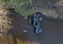 photographs show a 4x4 being recovered from a swollen river following the death of three men who were 'swept away' by floodwater.