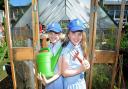 Sisters, Ruby and Lilly Lovett getting to work in the greenhouse in St Columba's School's Quad Garden.