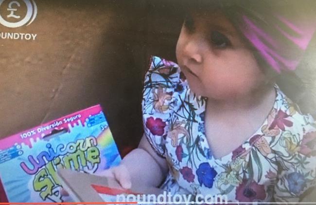 A young girl opens up a toy from PoundToy as featured in the firm's new TV advert