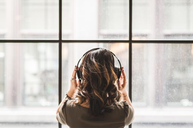 Bradford Telegraph and Argus: A woman listening to music on her headphones. Credit: Canva